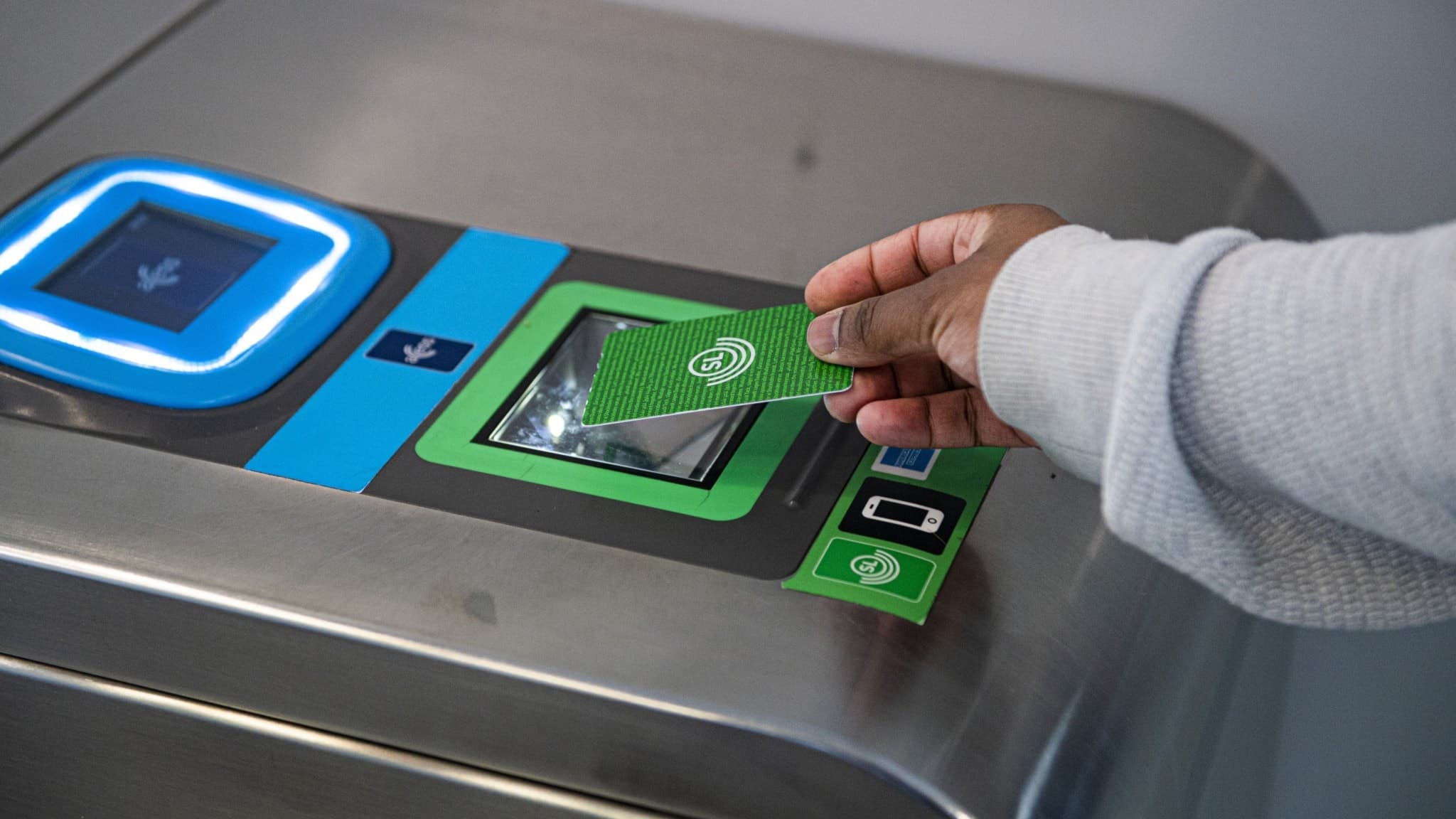 Person "blippar" grönt SL- kort vid tunnelbanespärr.