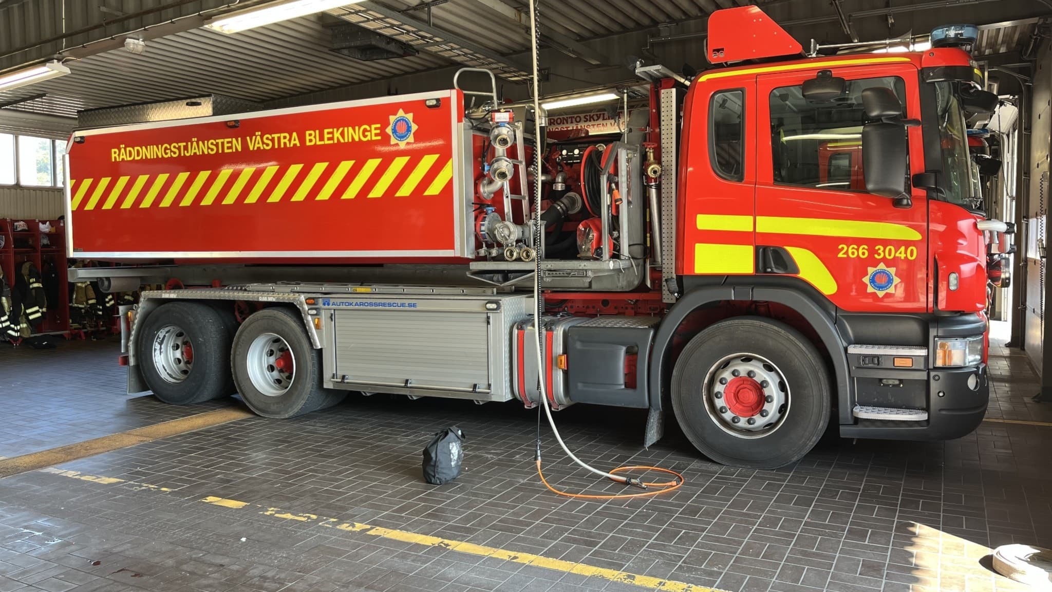 En gul och röd brandbil i garaget på brandstationen i Karlshamn. 