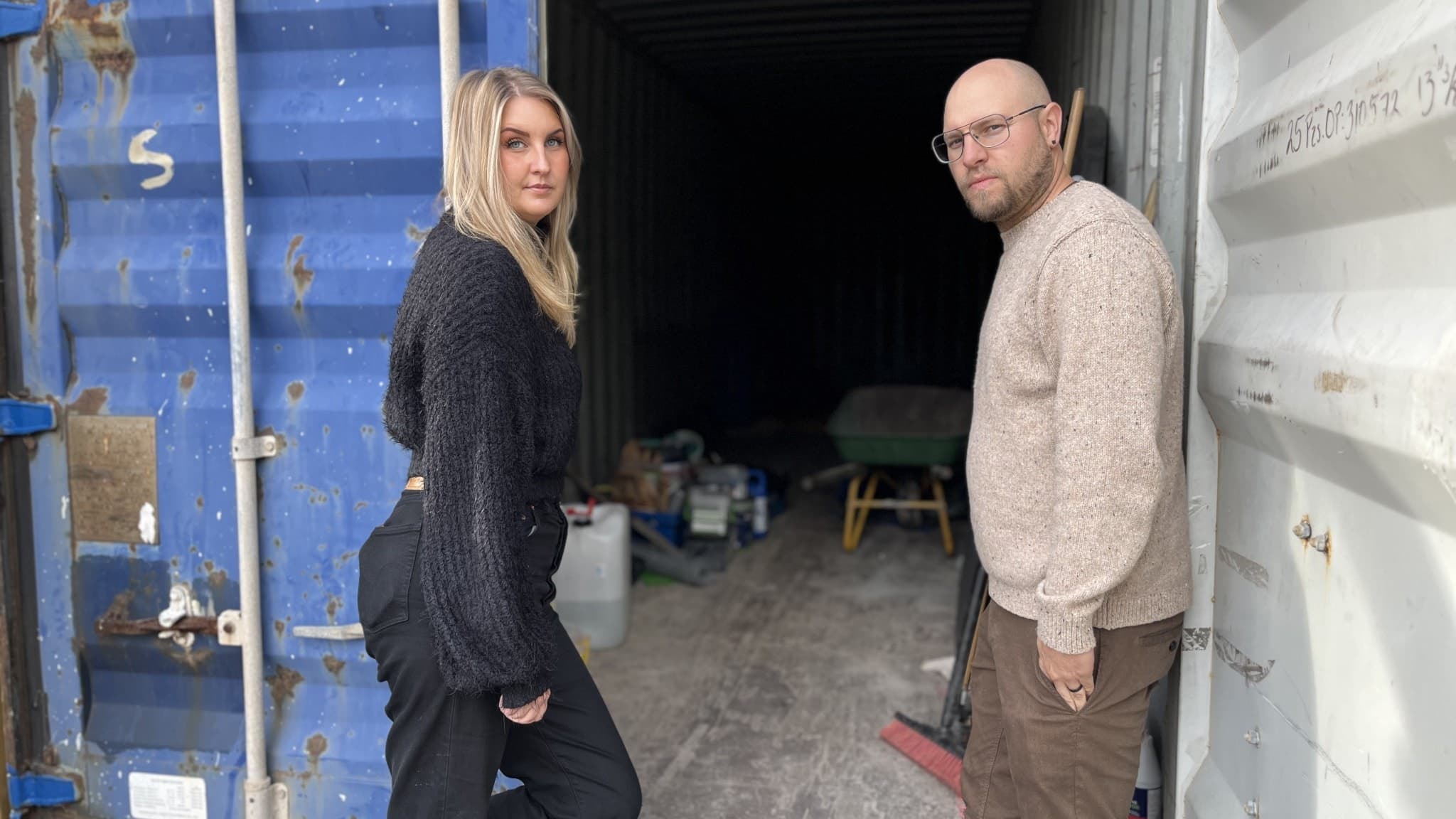 Emelie Vesterberg, huvudtränare och ordförande för cykelsektionen på Braås GOIF, samt Fredric Skarenberg vid en tömd container. Containern står öppen med verktyg och utrustning synligt inuti.