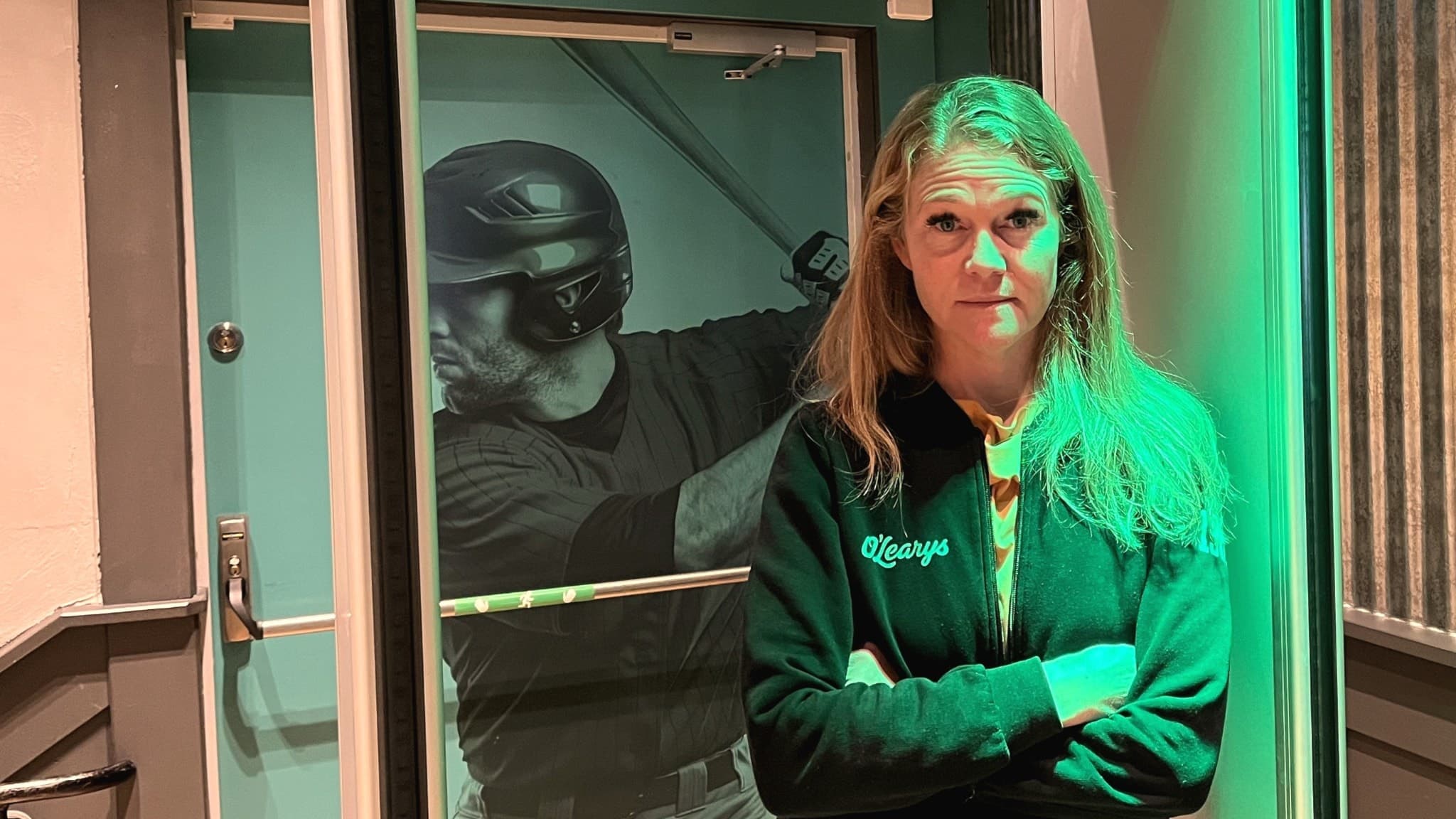Karin Granlund, platschef på O'Learys i Västerås, står med korslagda armar framför en larmbåge.