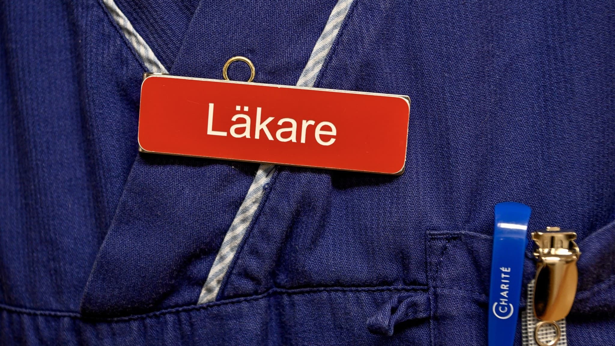Läkarbricka fast satt på en läkarrock. 