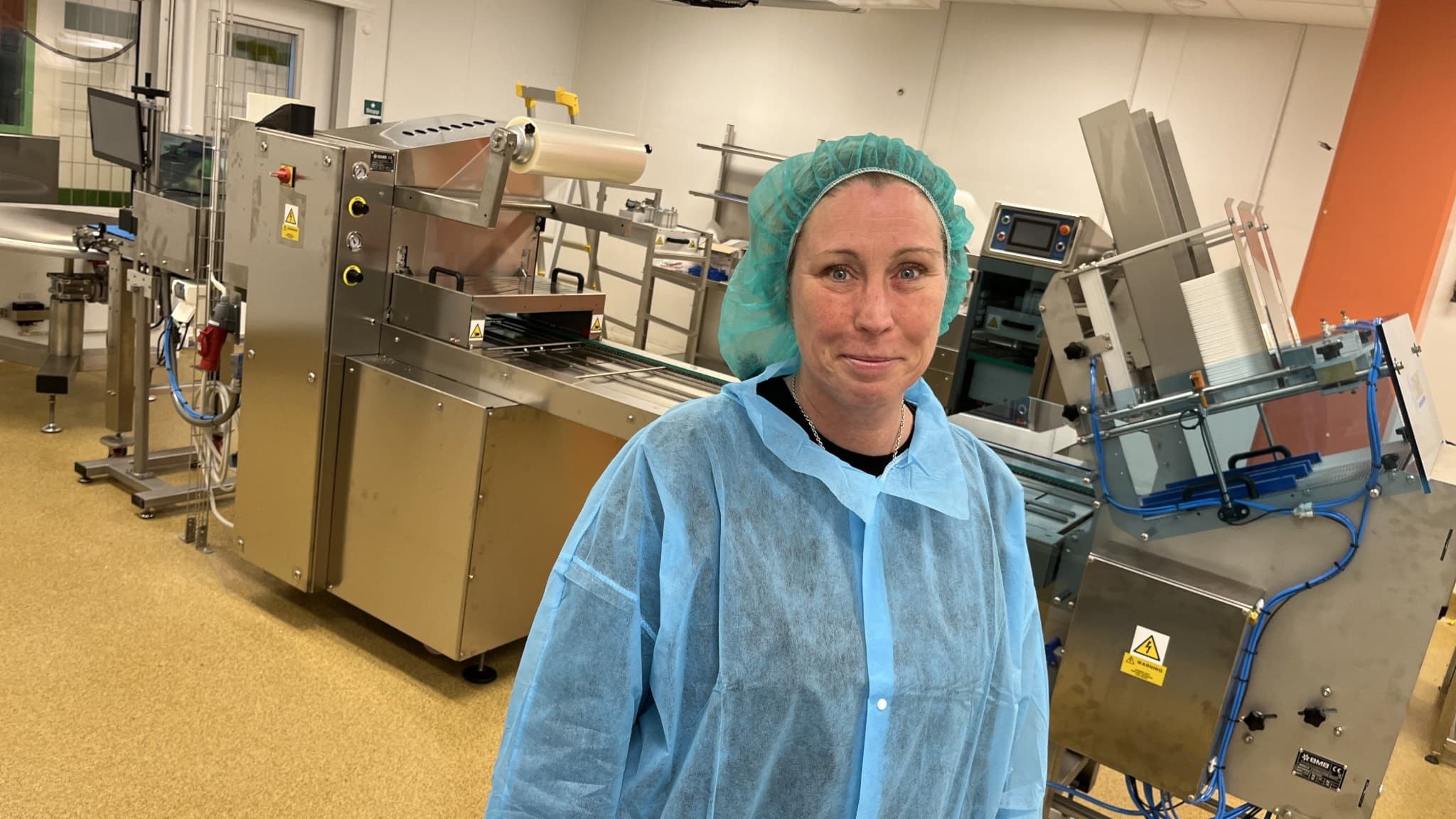 Izabelle Eriksson Länschef Måltidsservice på Region Örebro län framför den stora rostfria maskineen som ska paketera patientmat.
