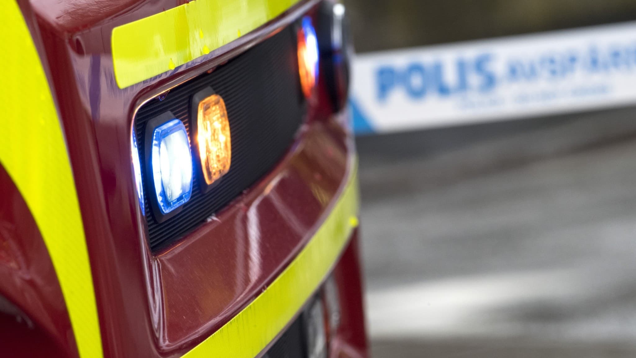 Genrebild på framdelen av en brandbil med polistejp i bakgrunden. 
