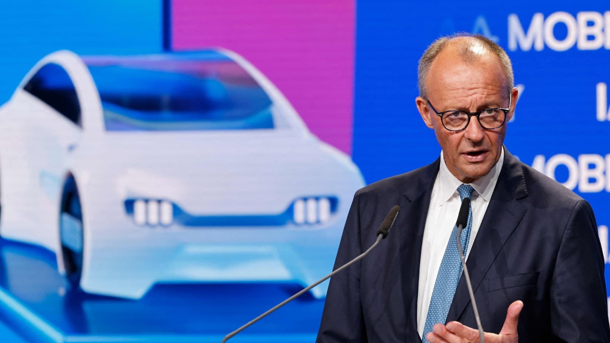 Friedrich Merz fram för en bild med bilar