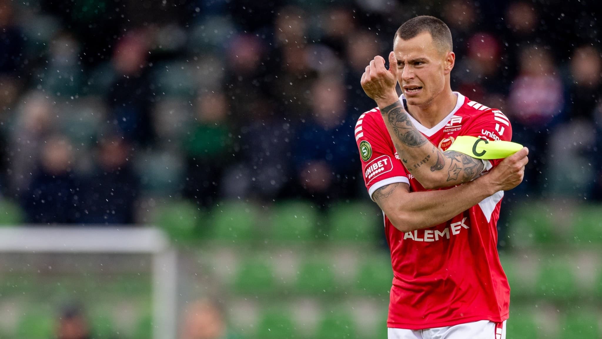 Lagkapten i fotboll sätter bindeln på plats.