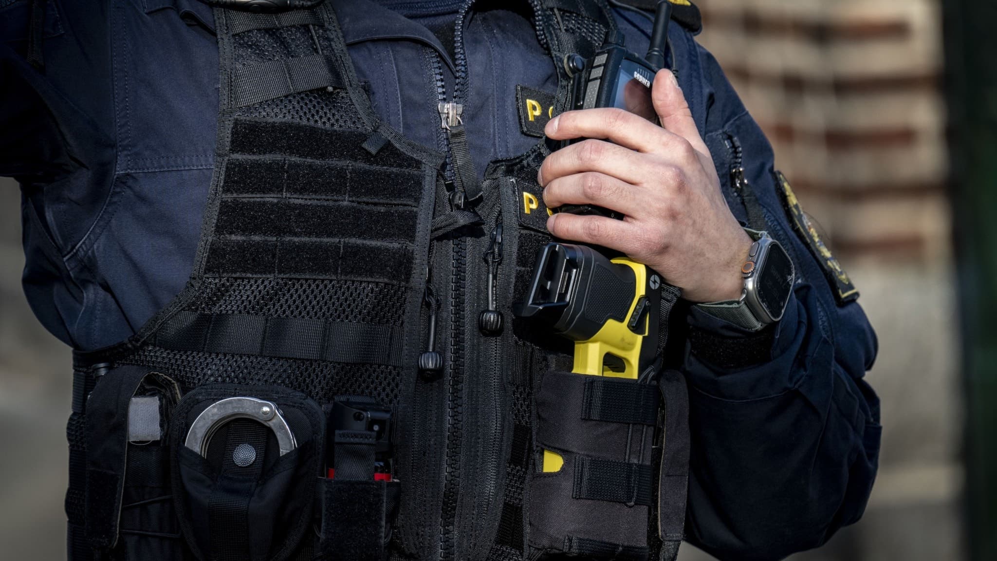 En polis i skyddsväst håller i en kommunikationsradio vid en avspärrning i området Södervärn, Malmö, efter ett misstänkt farligt föremål och en anmälan om olaga hot mot grupp.