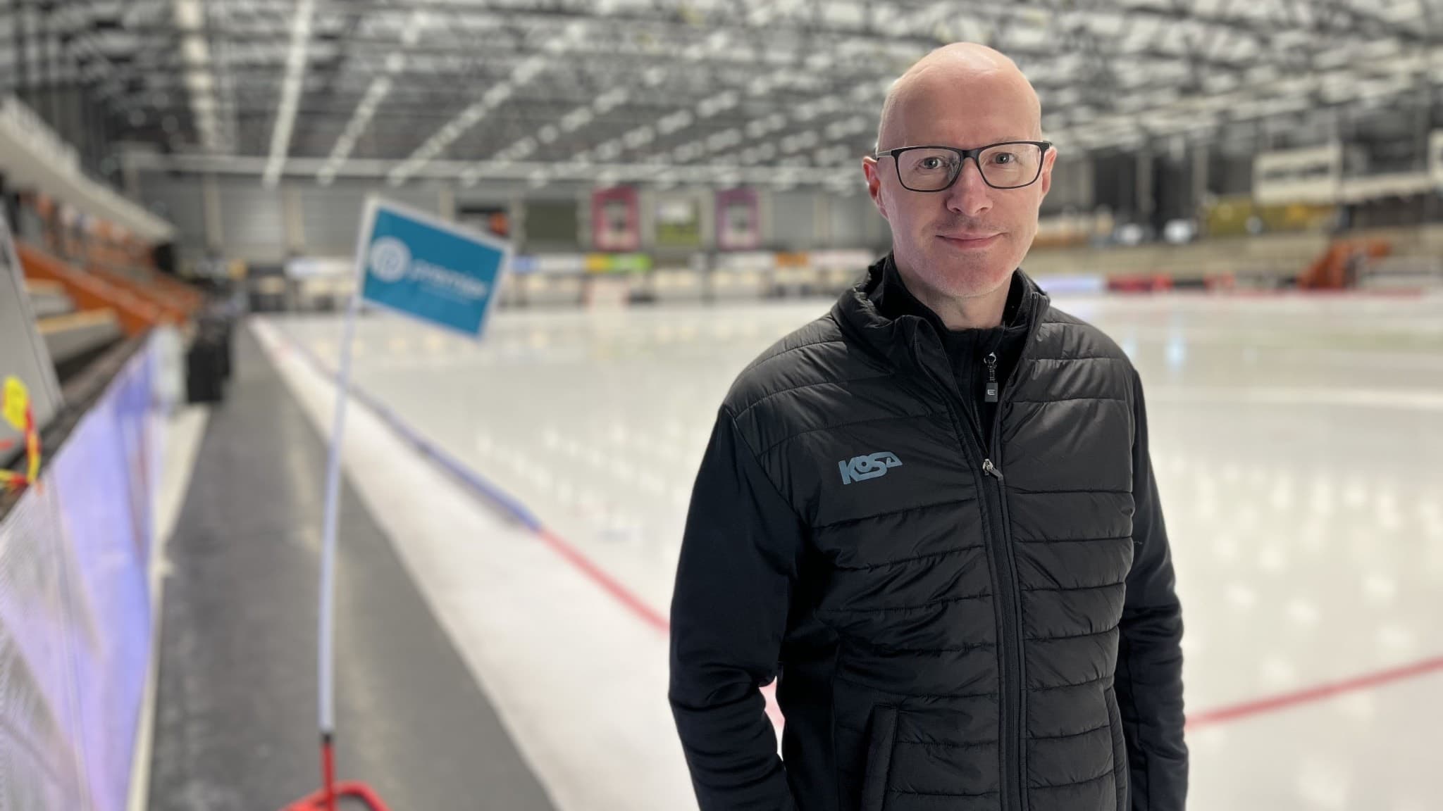 Pär Gustafsson från Bandyförbundet står vid en bandyarena med isbana i bakgrunden. Han bär en svart jacka med förbundets logotyp och interiören visar läktare och tak med belysning.