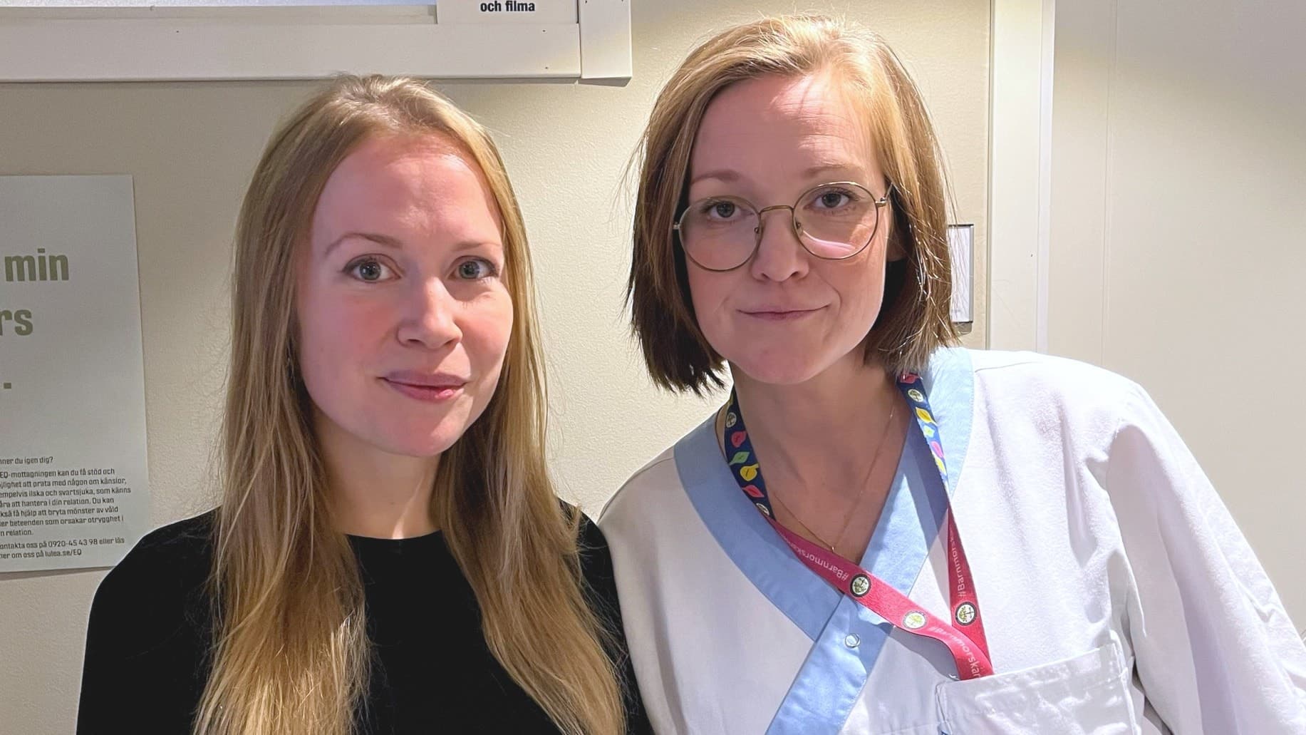 Ellinor Öhman, kurator, och Ellen Hansson, undersköterska, från Luleå ungdomsmottagning står framför en vägg med information för besökare.