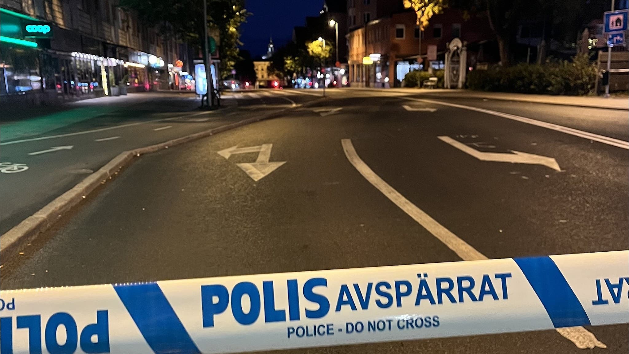 Polisavspärrning på en mörklagd gata söder om Gävle, med tydliga avspärrningsband som markerar området. Gatubelysning lyser upp vägbanan och omgivande byggnader syns i bakgrunden.