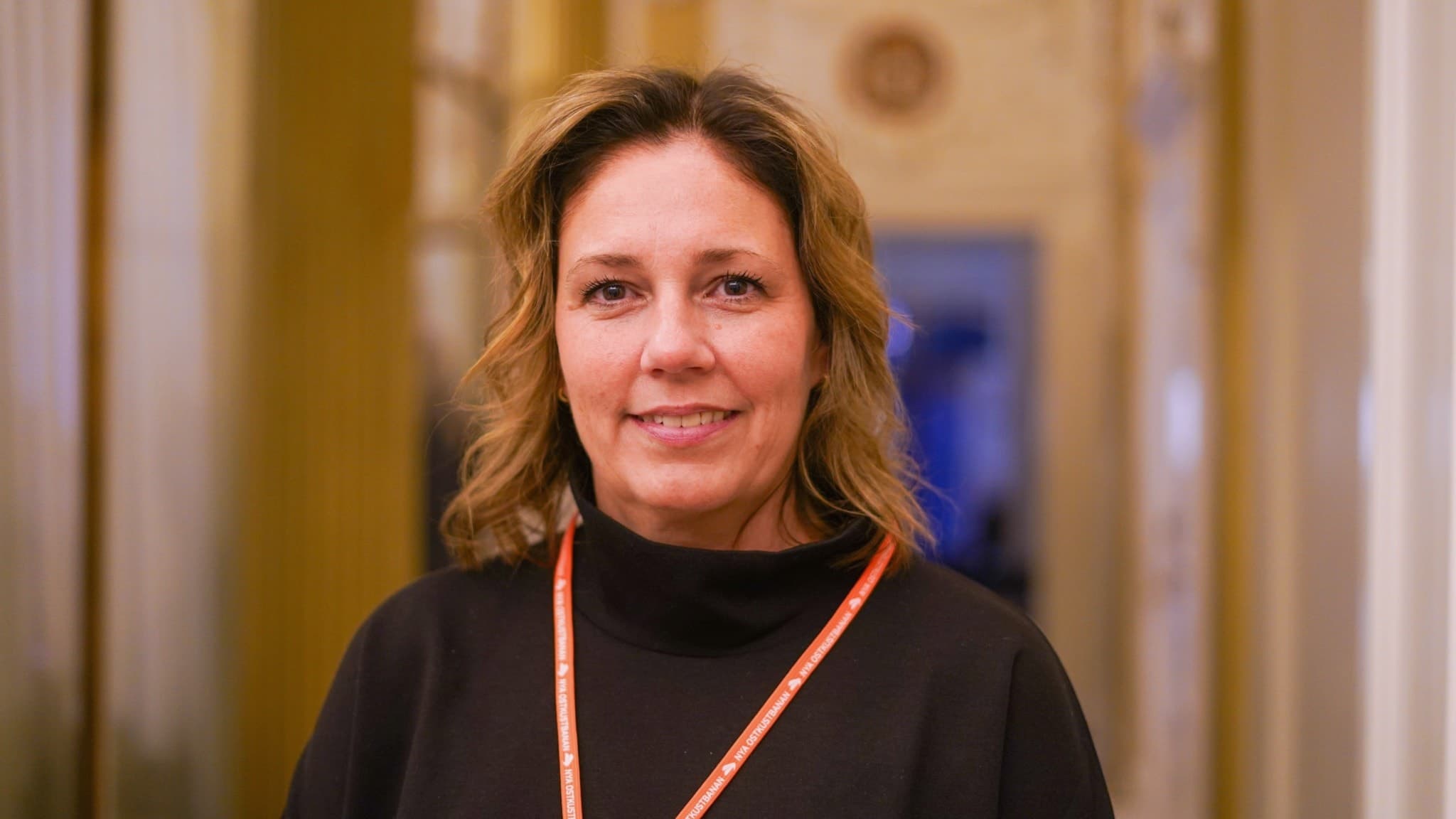 Helena Werre, regional direktör på Trafikverket Region norra, står inomhus med en röd namnbricka runt halsen.