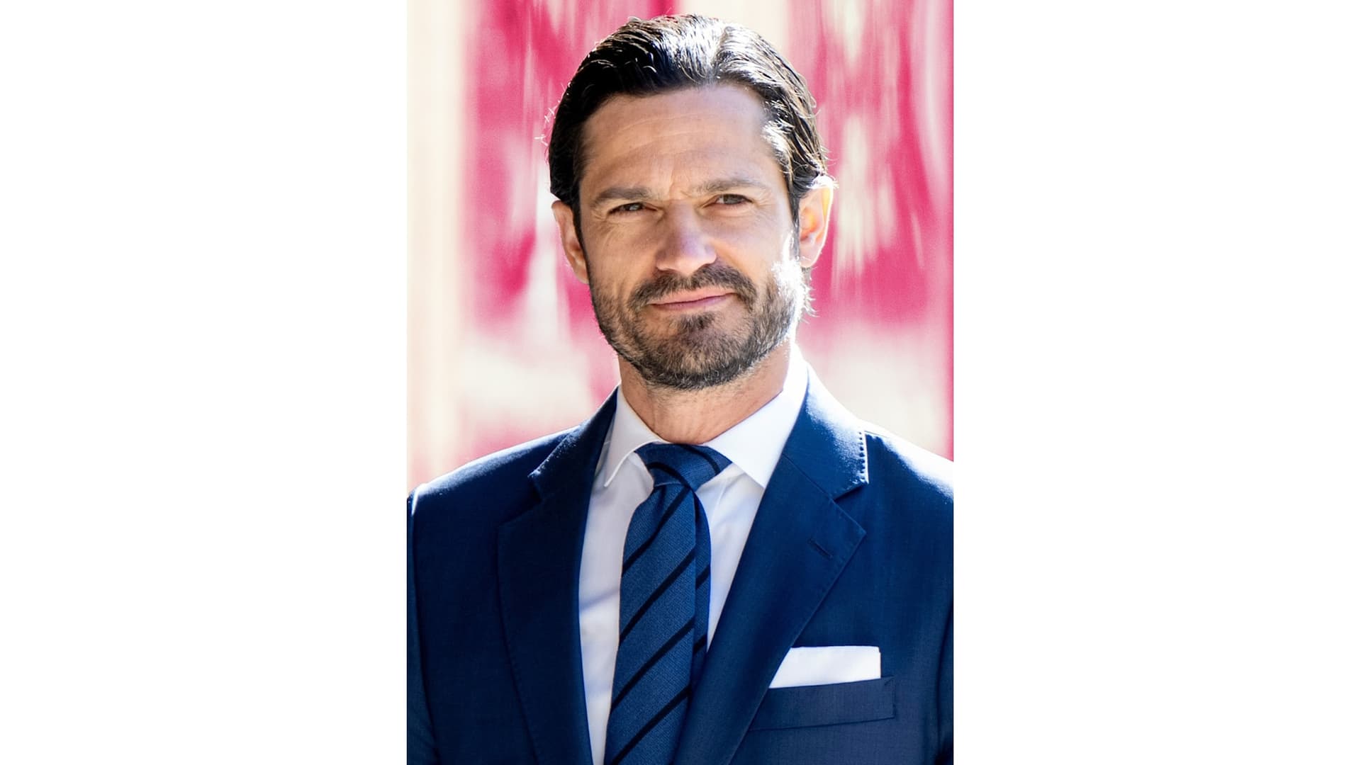 Prins Carl Philip mot en rosa bakgrund.