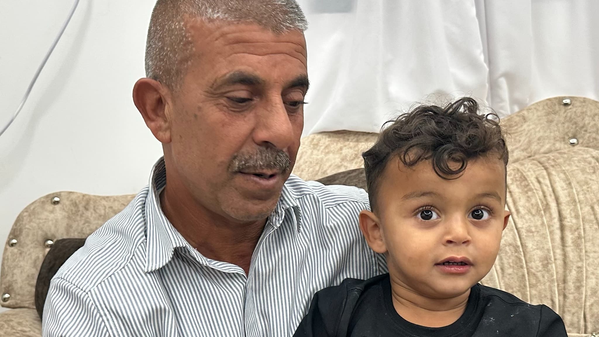 Hamid Abu Arar sitter med sin son Elias i knät.
