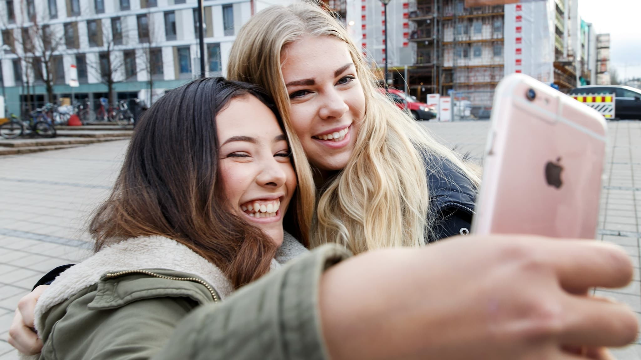 Två unga tonårstjejer ler stort när de tar en selfie med en rosa mobil. Foto: Gorm Kallestad/NTB/TT