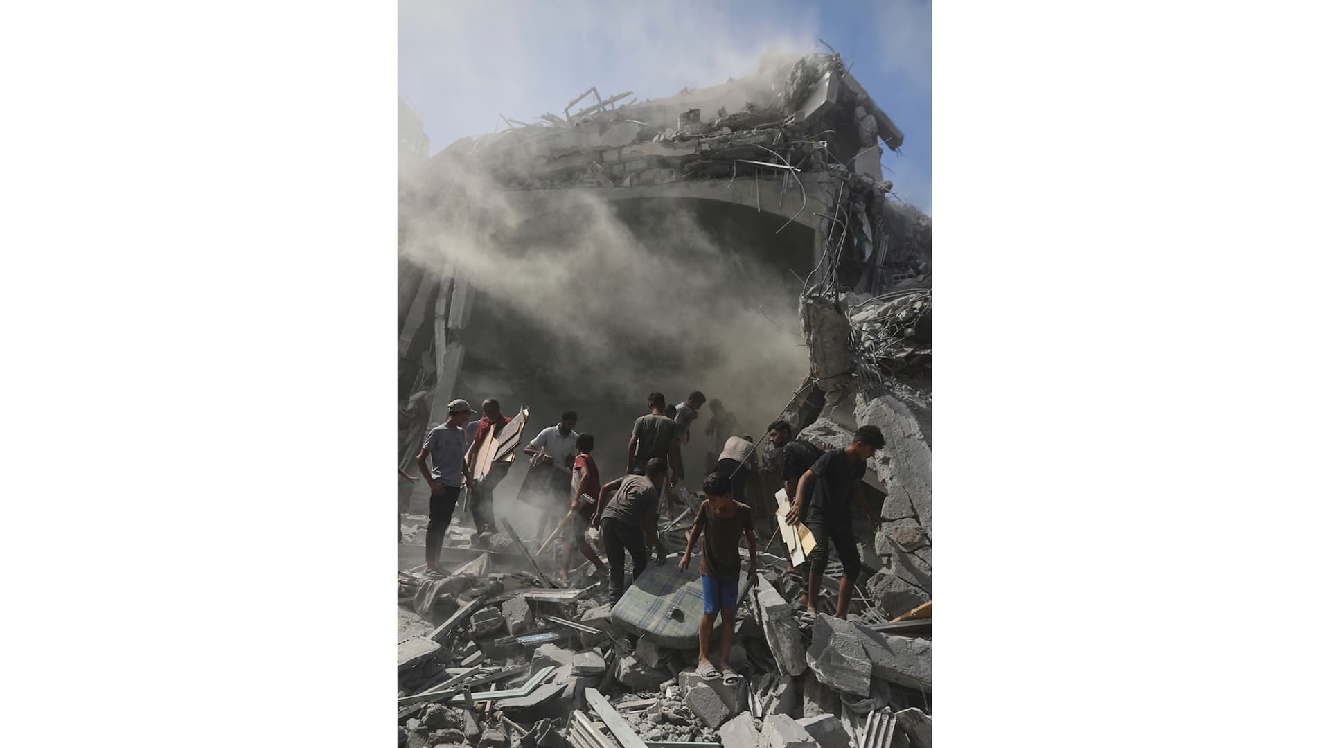 Personer går runt i rasmassorna efter en attack i Gaza Stad.